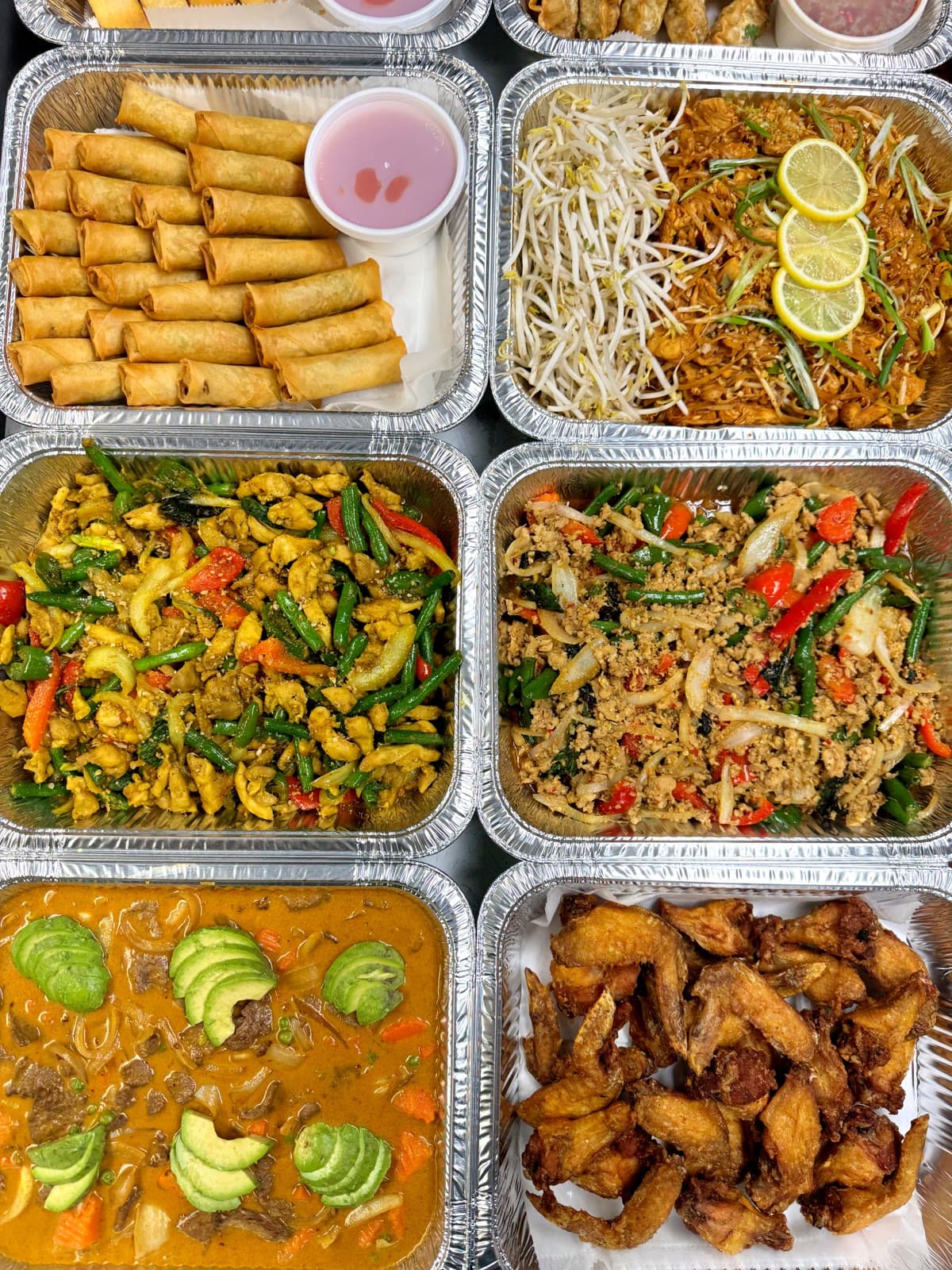 Six-tray catering layout with spring rolls, noodles, stir-fry, and wings